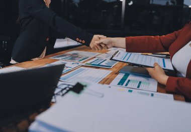 Ofis toplantısında iki farklı profesyonel iş adamı yönetici lider el sıkışıyor.