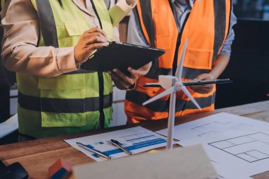 Mühendisler proje türlerinin yapısal analizi ve planları üzerinde çalışmalara yardım ediyorlar..