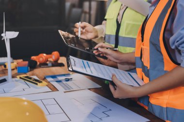 Mühendisler proje türlerinin yapısal analizi ve planları üzerinde çalışmalara yardım ediyorlar..