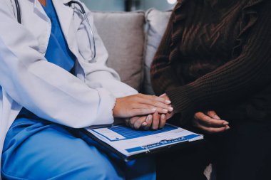 Doktor hastayı kontrol etmeye geldi ve cesaretlendirmek için elini sıktı. Hastanede tedavi edilenleri ve hastaları teselli etmek..