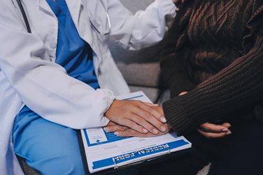 Doktor hastayı kontrol etmeye geldi ve cesaretlendirmek için elini sıktı. Hastanede tedavi edilenleri ve hastaları teselli etmek..