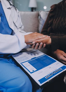 Doktor hastayı kontrol etmeye geldi ve cesaretlendirmek için elini sıktı. Hastanede tedavi edilenleri ve hastaları teselli etmek..