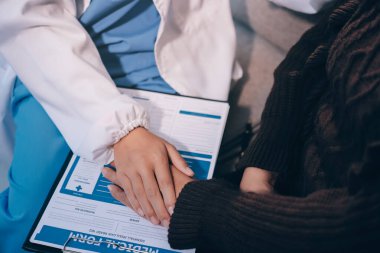 Doktor hastayı kontrol etmeye geldi ve cesaretlendirmek için elini sıktı. Hastanede tedavi edilenleri ve hastaları teselli etmek..