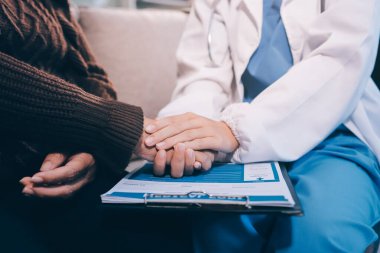 Doktor hastayı kontrol etmeye geldi ve cesaretlendirmek için elini sıktı. Hastanede tedavi edilenleri ve hastaları teselli etmek..