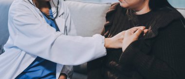 Ev bakımı hemşiresi ve yaşlılar kardiyoloji sağlık hizmetleri. Genç İspanyol kadın doktor hemşirenin yakın çekimleri sırasında steteskop kullanarak olgun beyaz hasta kalp atışlarını kontrol et.