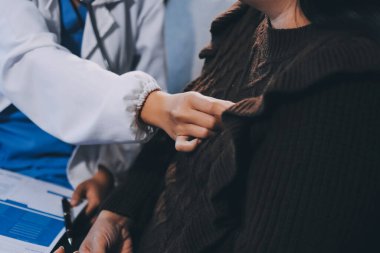 Ev bakımı hemşiresi ve yaşlılar kardiyoloji sağlık hizmetleri. Genç İspanyol kadın doktor hemşirenin yakın çekimleri sırasında steteskop kullanarak olgun beyaz hasta kalp atışlarını kontrol et.