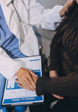 Doktor hastayı kontrol etmeye geldi ve cesaretlendirmek için elini sıktı. Hastanede tedavi edilenleri ve hastaları teselli etmek..