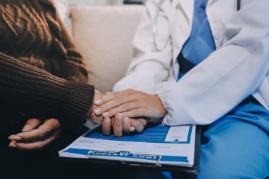 Doktor hastayı kontrol etmeye geldi ve cesaretlendirmek için elini sıktı. Hastanede tedavi edilenleri ve hastaları teselli etmek..