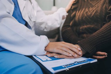 Doktor hastayı kontrol etmeye geldi ve cesaretlendirmek için elini sıktı. Hastanede tedavi edilenleri ve hastaları teselli etmek..