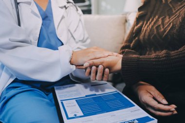 Doktor hastayı kontrol etmeye geldi ve cesaretlendirmek için elini sıktı. Hastanede tedavi edilenleri ve hastaları teselli etmek..