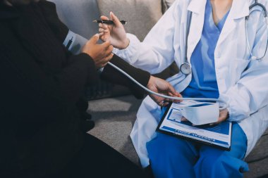 Kan basıncı monitörü ve steteskop kullanan doktor kolundaki kan basıncını ölçmek için hastanedeki bir hastaya, sağlık hizmetlerine ve tıbbi konsepte bakıyor.