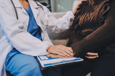 Doktor hastayı kontrol etmeye geldi ve cesaretlendirmek için elini sıktı. Hastanede tedavi edilenleri ve hastaları teselli etmek..