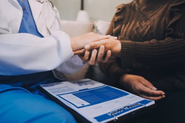 Doktor hastayı kontrol etmeye geldi ve cesaretlendirmek için elini sıktı. Hastanede tedavi edilenleri ve hastaları teselli etmek..