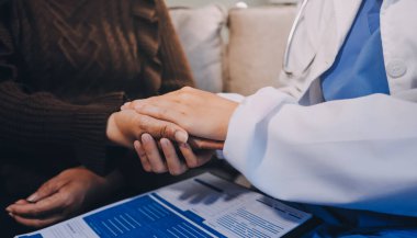 Doktor hastayı kontrol etmeye geldi ve cesaretlendirmek için elini sıktı. Hastanede tedavi edilenleri ve hastaları teselli etmek..