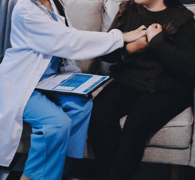 Ev bakımı hemşiresi ve yaşlılar kardiyoloji sağlık hizmetleri. Genç İspanyol kadın doktor hemşirenin yakın çekimleri sırasında steteskop kullanarak olgun beyaz hasta kalp atışlarını kontrol et.