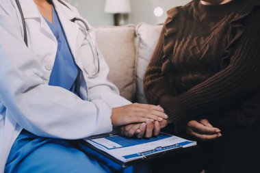 Doktor hastayı kontrol etmeye geldi ve cesaretlendirmek için elini sıktı. Hastanede tedavi edilenleri ve hastaları teselli etmek..