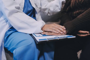 Doktor hastayı kontrol etmeye geldi ve cesaretlendirmek için elini sıktı. Hastanede tedavi edilenleri ve hastaları teselli etmek..