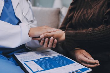 Doktor hastayı kontrol etmeye geldi ve cesaretlendirmek için elini sıktı. Hastanede tedavi edilenleri ve hastaları teselli etmek..