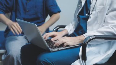 Doktor ve hasta hastanede sağlık sorunlarını tartışıyorlar. Bilgisayarlı doktor hastane ofisinde..
