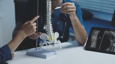 Genç doktor hastanın röntgenini gösteriyor.