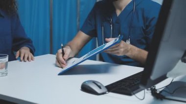 Doktor ve hemşire laptopta tıbbi maske takıyor.