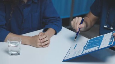 Genç bir kadın elinde kalem tutuyor, belgeye bakıyor, ofisteki masada oturuyor, iş konsepti...,