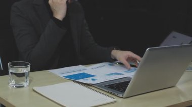 Ofiste dizüstü bilgisayarda çalışan iş adamı.