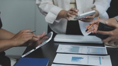 Masa başında belgelerle çalışan iş adamlarını kapatın.