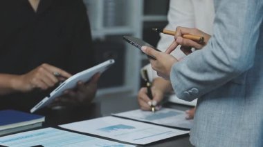 İş yerindeki mali belgelerle çalışan iş adamlarını kapatın. İş adamları ofiste toplanıyor..