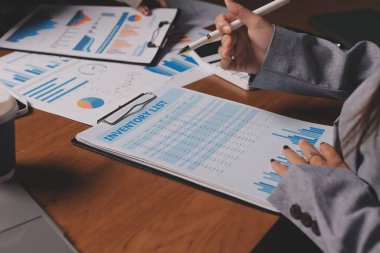 Group of confident business people point to graphs and charts to analyze market data, balance sheet, account, net profit to plan new sales strategies to increase production capacity.