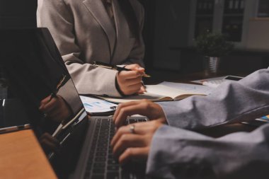 Group of confident business people point to graphs and charts to analyze market data, balance sheet, account, net profit to plan new sales strategies to increase production capacity.