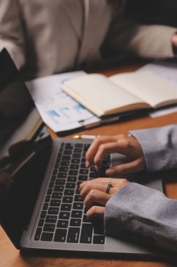 Group of confident business people point to graphs and charts to analyze market data, balance sheet, account, net profit to plan new sales strategies to increase production capacity.
