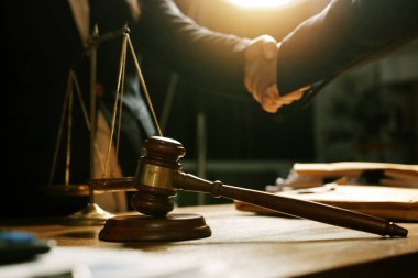 Ofisteki çekici genç avukat iş kadını ve avukatlar ofisdeki ahşap masada pirinç pullu kağıtları tartışıyorlar. Hukuk, hukuk hizmetleri, danışmanlık, Adalet ve emlak kavramı.