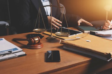 Ofisteki çekici genç avukat iş kadını ve avukatlar ofisdeki ahşap masada pirinç pullu kağıtları tartışıyorlar. Hukuk, hukuk hizmetleri, danışmanlık, Adalet ve emlak kavramı.