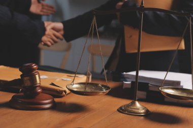 Ofisteki çekici genç avukat iş kadını ve avukatlar ofisdeki ahşap masada pirinç pullu kağıtları tartışıyorlar. Hukuk, hukuk hizmetleri, danışmanlık, Adalet ve emlak kavramı.