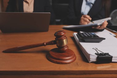 Ofisteki çekici genç avukat iş kadını ve avukatlar ofisdeki ahşap masada pirinç pullu kağıtları tartışıyorlar. Hukuk, hukuk hizmetleri, danışmanlık, Adalet ve emlak kavramı.