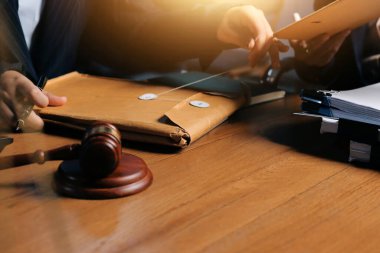 Ofisteki çekici genç avukat iş kadını ve avukatlar ofisdeki ahşap masada pirinç pullu kağıtları tartışıyorlar. Hukuk, hukuk hizmetleri, danışmanlık, Adalet ve emlak kavramı.