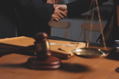 Ofisteki çekici genç avukat iş kadını ve avukatlar ofisdeki ahşap masada pirinç pullu kağıtları tartışıyorlar. Hukuk, hukuk hizmetleri, danışmanlık, Adalet ve emlak kavramı.