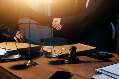 Ofisteki çekici genç avukat iş kadını ve avukatlar ofisdeki ahşap masada pirinç pullu kağıtları tartışıyorlar. Hukuk, hukuk hizmetleri, danışmanlık, Adalet ve emlak kavramı.