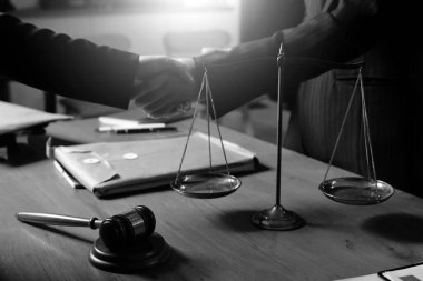 Ofisteki çekici genç avukat iş kadını ve avukatlar ofisdeki ahşap masada pirinç pullu kağıtları tartışıyorlar. Hukuk, hukuk hizmetleri, danışmanlık, Adalet ve emlak kavramı.