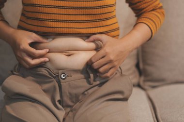 Şişman karnına dokunup sıkarken çekilmiş bir fotoğraf..