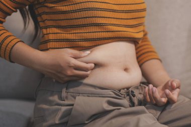 Şişman karnına dokunup sıkarken çekilmiş bir fotoğraf..