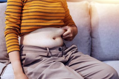 Şişman karnına dokunup sıkarken çekilmiş bir fotoğraf..