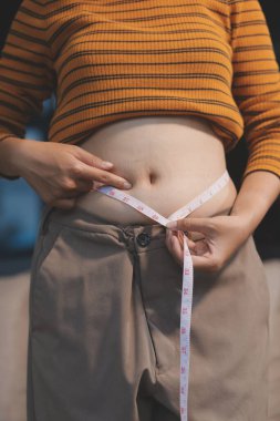 Şişman karnına dokunup sıkarken çekilmiş bir fotoğraf..