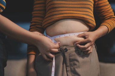 Şişman karnına dokunup sıkarken çekilmiş bir fotoğraf..