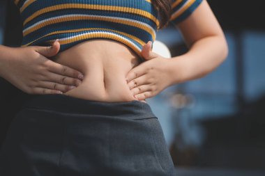 Şişman karnına dokunup sıkarken çekilmiş bir fotoğraf..