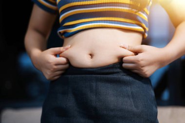 Şişman karnına dokunup sıkarken çekilmiş bir fotoğraf..