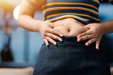 Şişman karnına dokunup sıkarken çekilmiş bir fotoğraf..