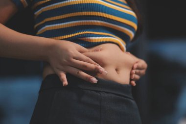 Şişman karnına dokunup sıkarken çekilmiş bir fotoğraf..