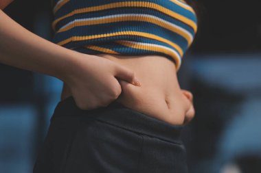 Şişman karnına dokunup sıkarken çekilmiş bir fotoğraf..